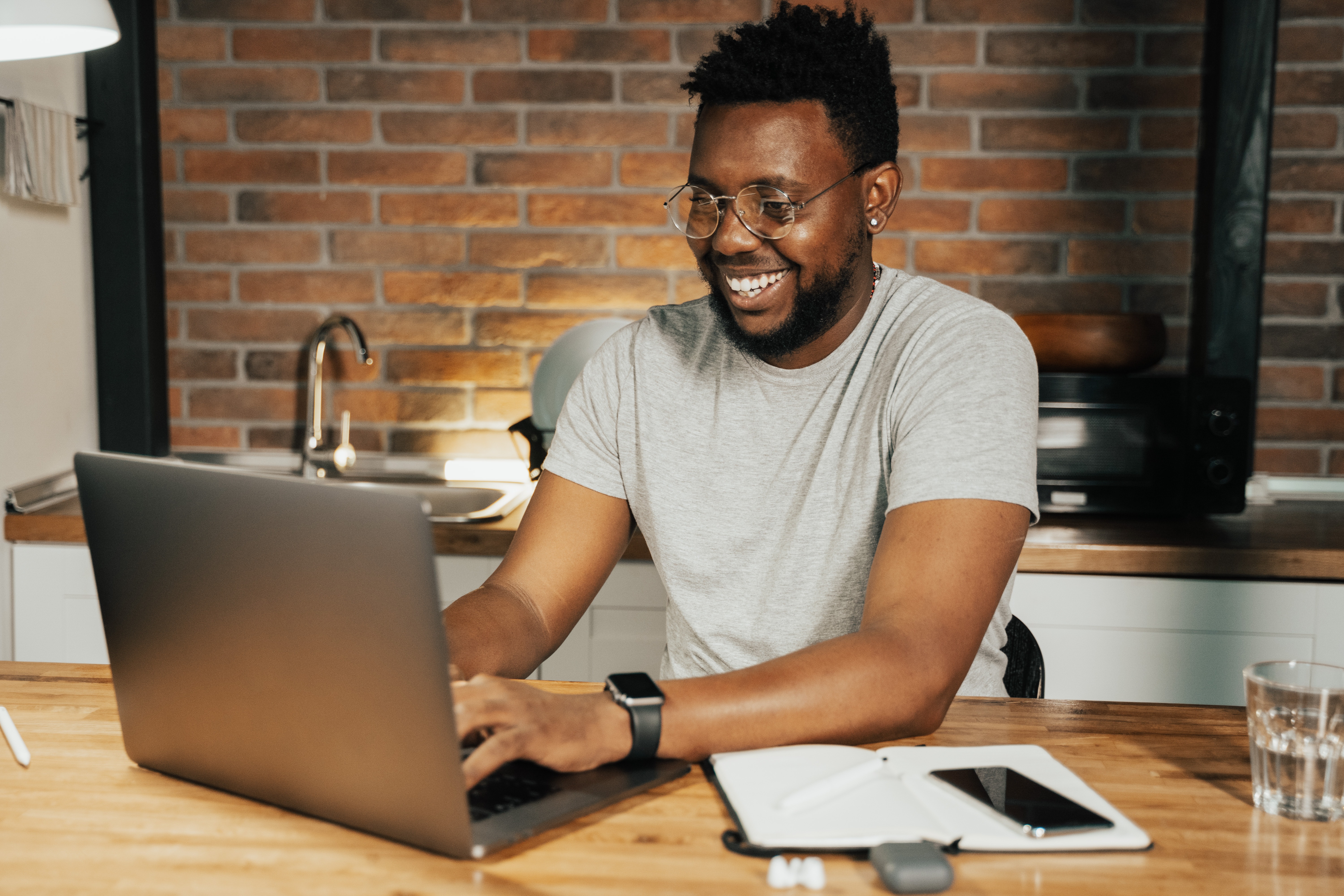 A man smiling while looking at his computer.